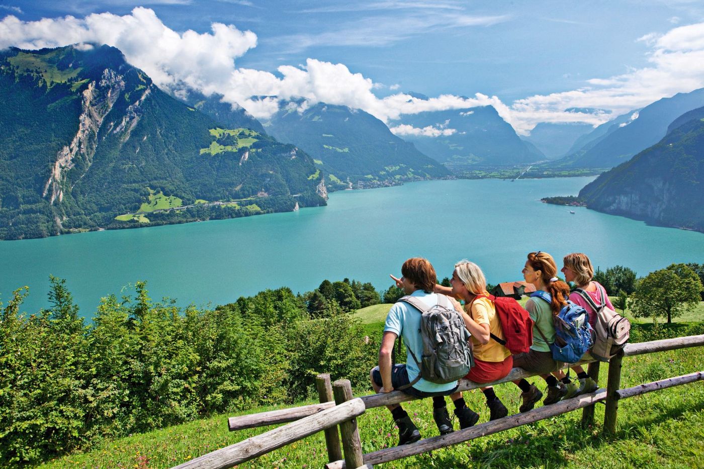 Group of hikers sitting on a wooden fence, looking out over Lake Lucerne-supplied by Eurotrek