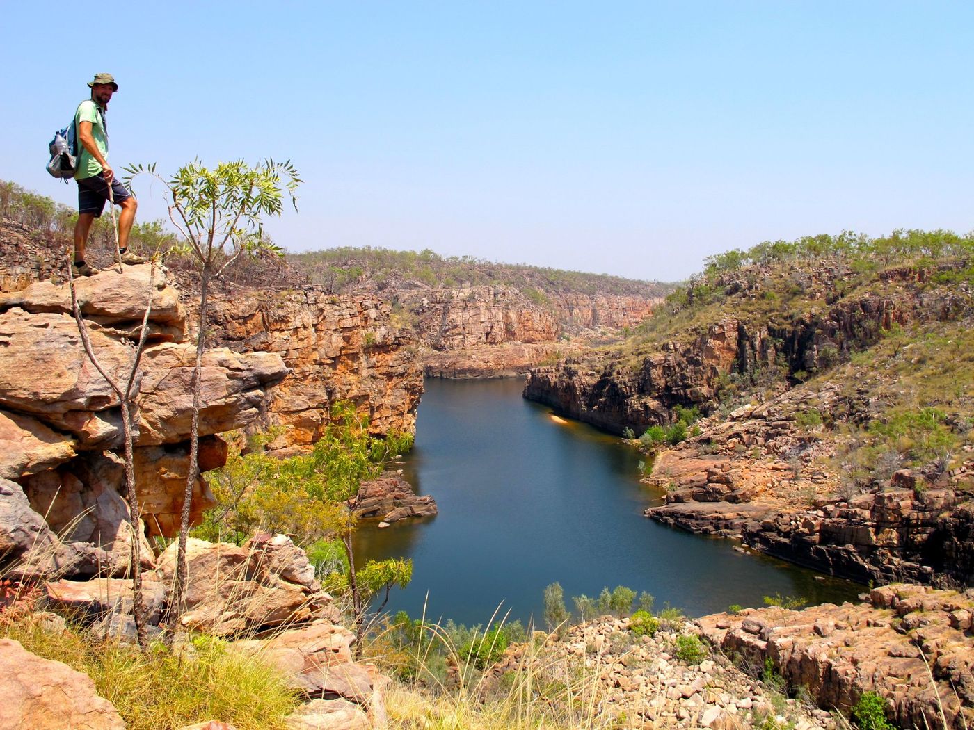 Hiker standing on the dramatic sandstone cliffs and winding river of Katherine Gorge in Nitmiluk National Park