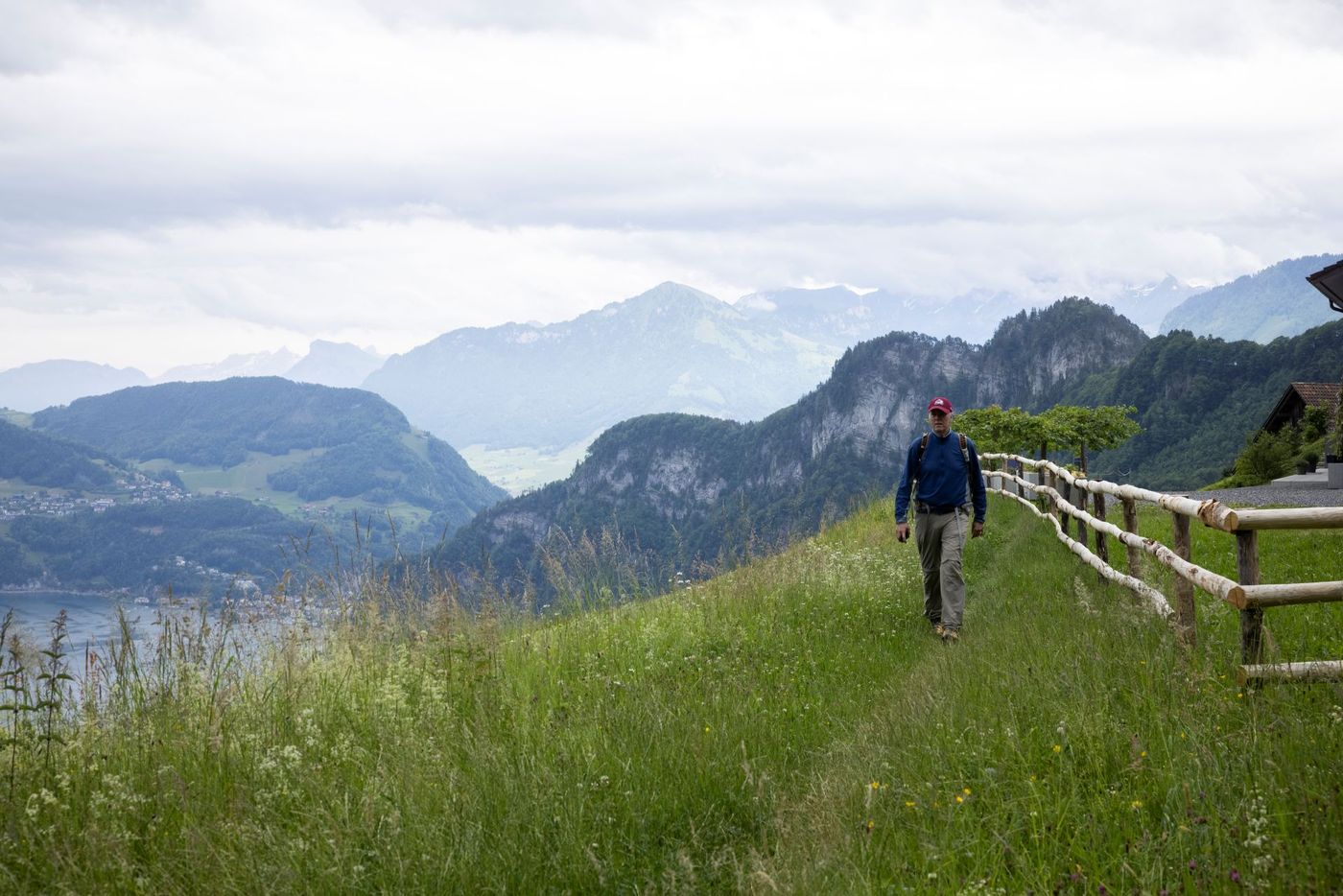 Hiker walking along a hillside path with views of Lake Lucerne-supplied by Eurortrek