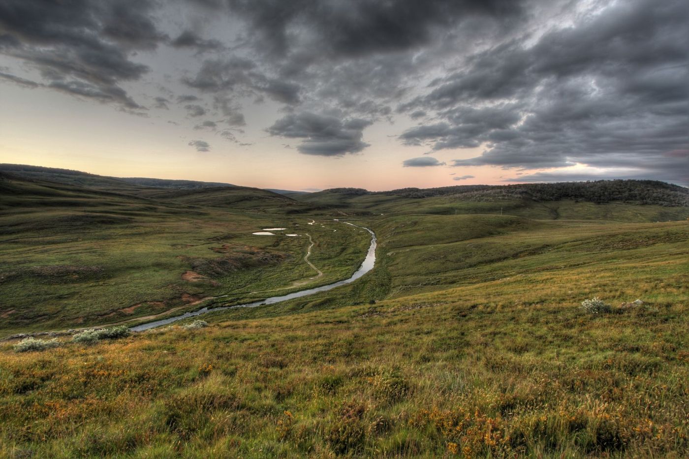 River-Meandering-Through-Summer-Alpine-Grasslands