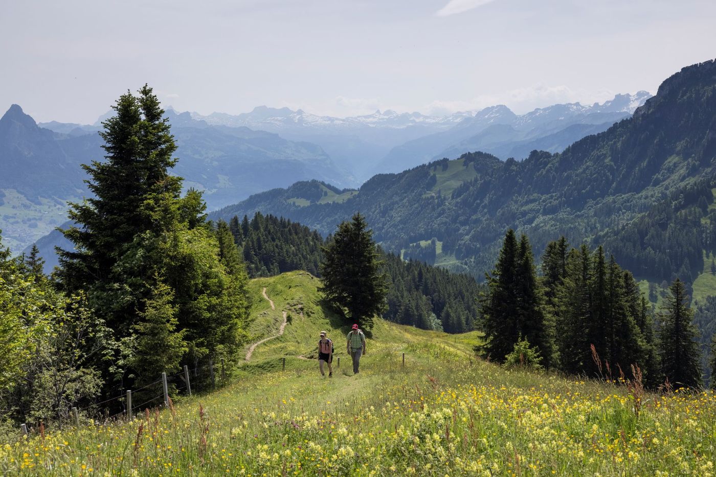 Two hikers walking along the trail through the mountains in the Lake Lucerne (Vierwaldstättersee) region of Central Switzerland-supplied by Eurortrek