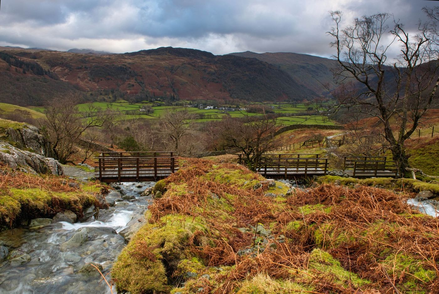 Wooden footbridges crossing a rushing mountain stream near Castle Crag